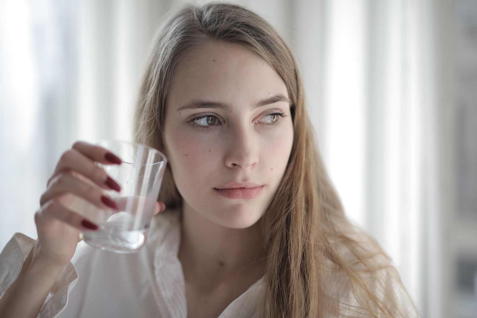 Bir bardak su tutan kadın — su tüketimi ve wellness